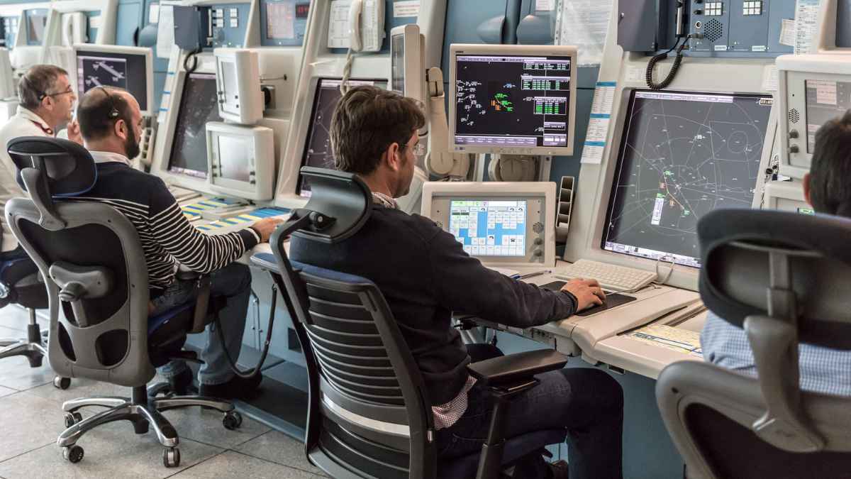 Controladores aéreos trabajando en sala de control durante su jornada laboral