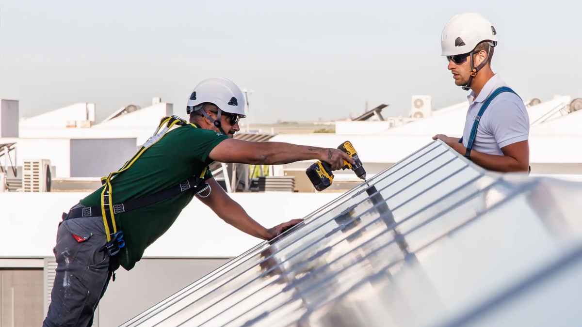 Instaladores de placas solares en tejado durante la instalación fotovoltaica doméstica