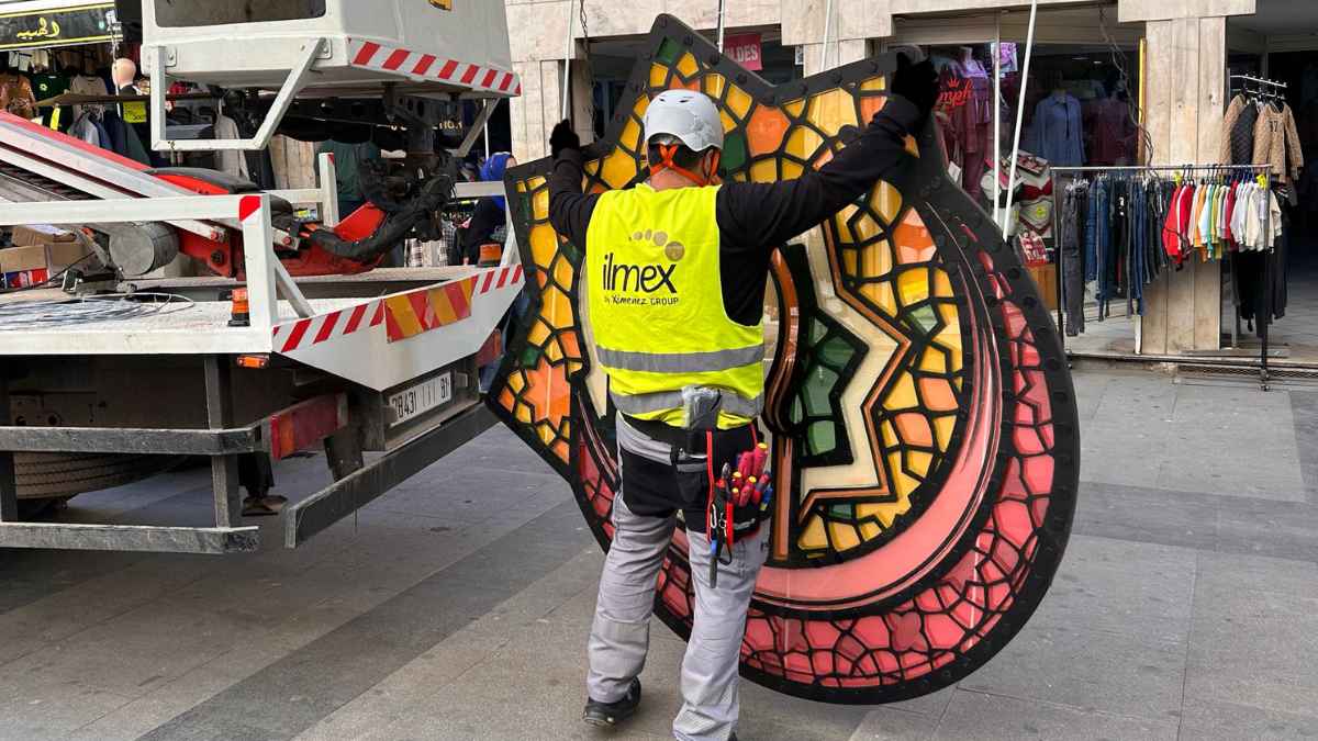 Trabajador de Ximénez Group instalando pieza decorativa de iluminación en la calle