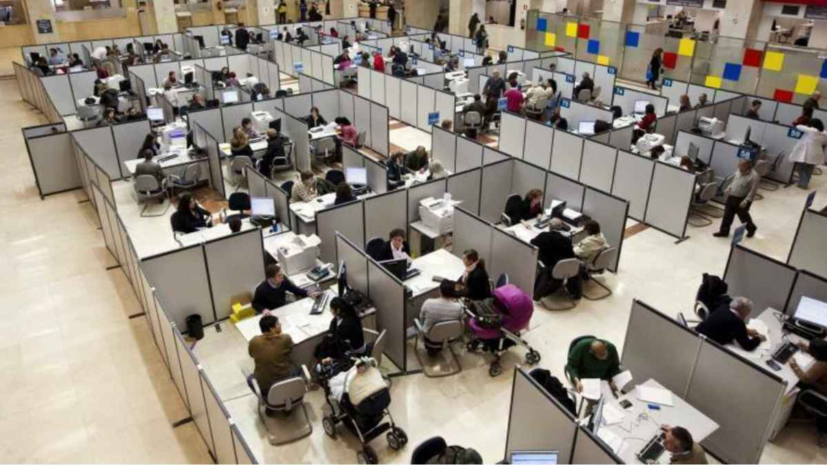 Funcionarios atendiendo trámites en una oficina pública durante el pago de la paguilla extra de diciembre