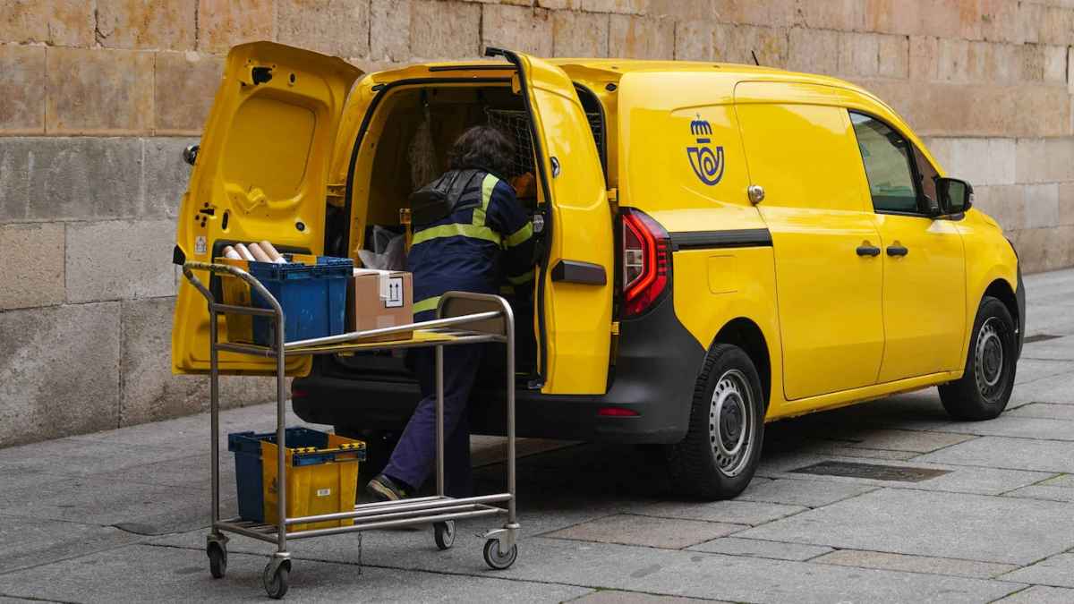 Cartero cargando una furgoneta de reparto durante su jornada laboral
