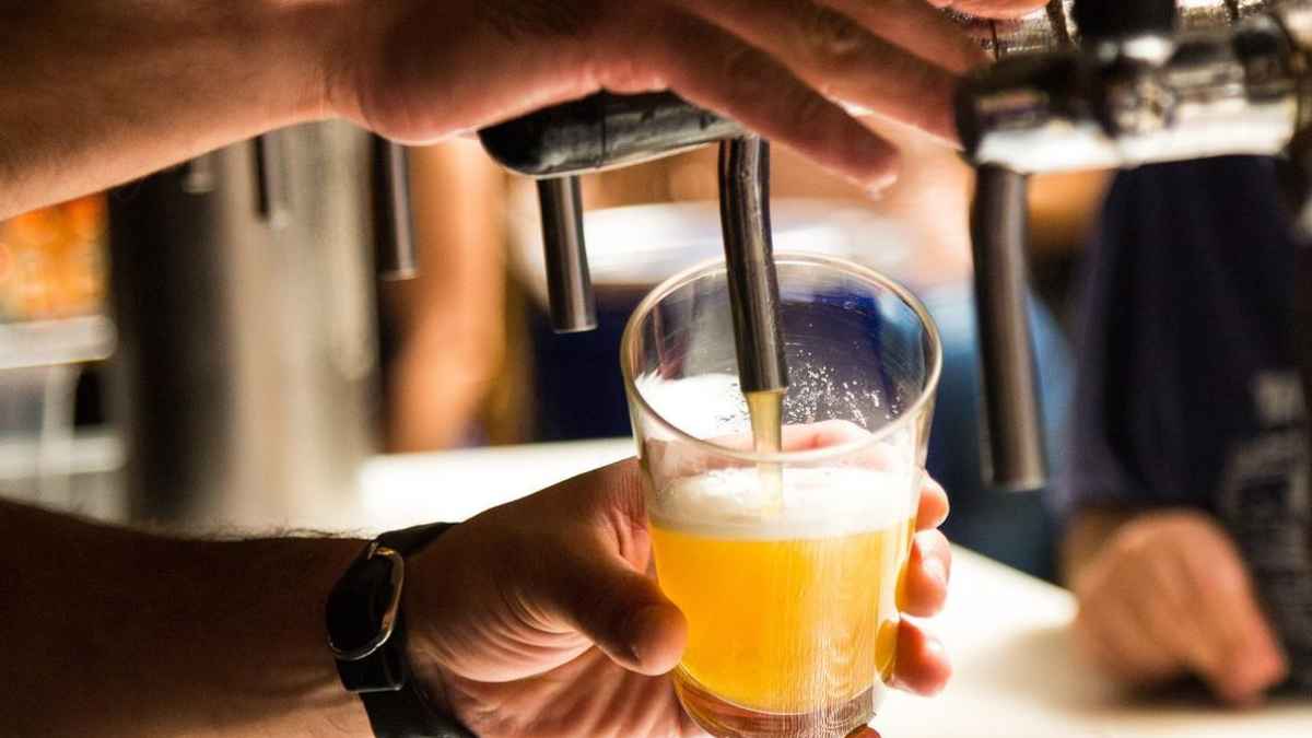 Camarero sirviendo una cerveza en un bar durante su jornada laboral