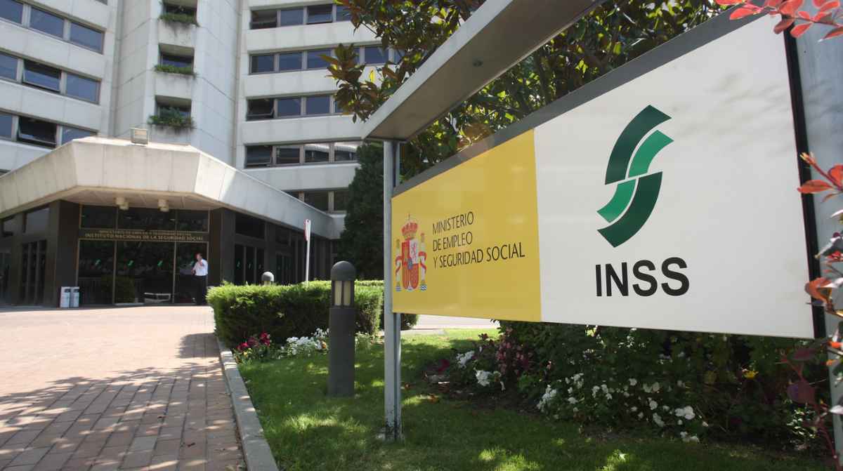 Fachada del INSS con cartel de la Seguridad Social relacionada con el bloqueo de prestaciones por deudas o errores en el IBAN