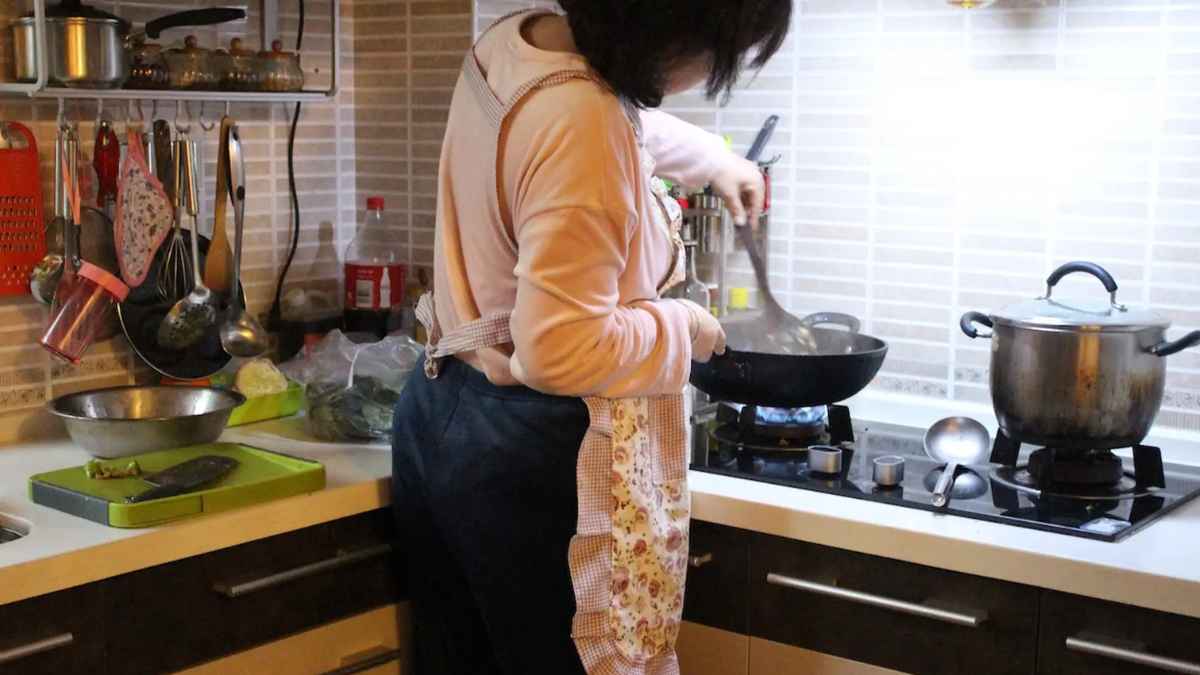 Ama de casa cocinando en su hogar mientras se informa sobre ayudas y prestaciones alternativas al subsidio por desempleo