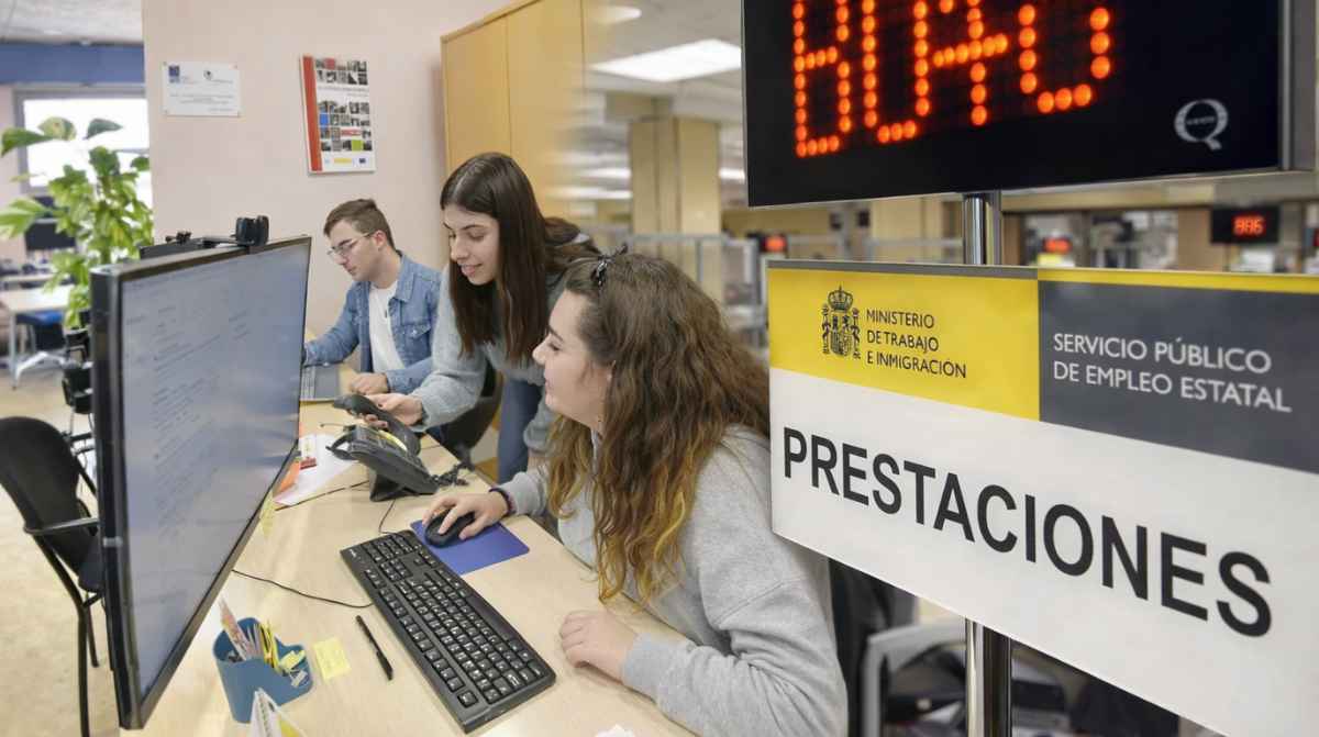 Becarios realizando prácticas en una oficina mientras el SEPE gestiona prestaciones por desempleo
