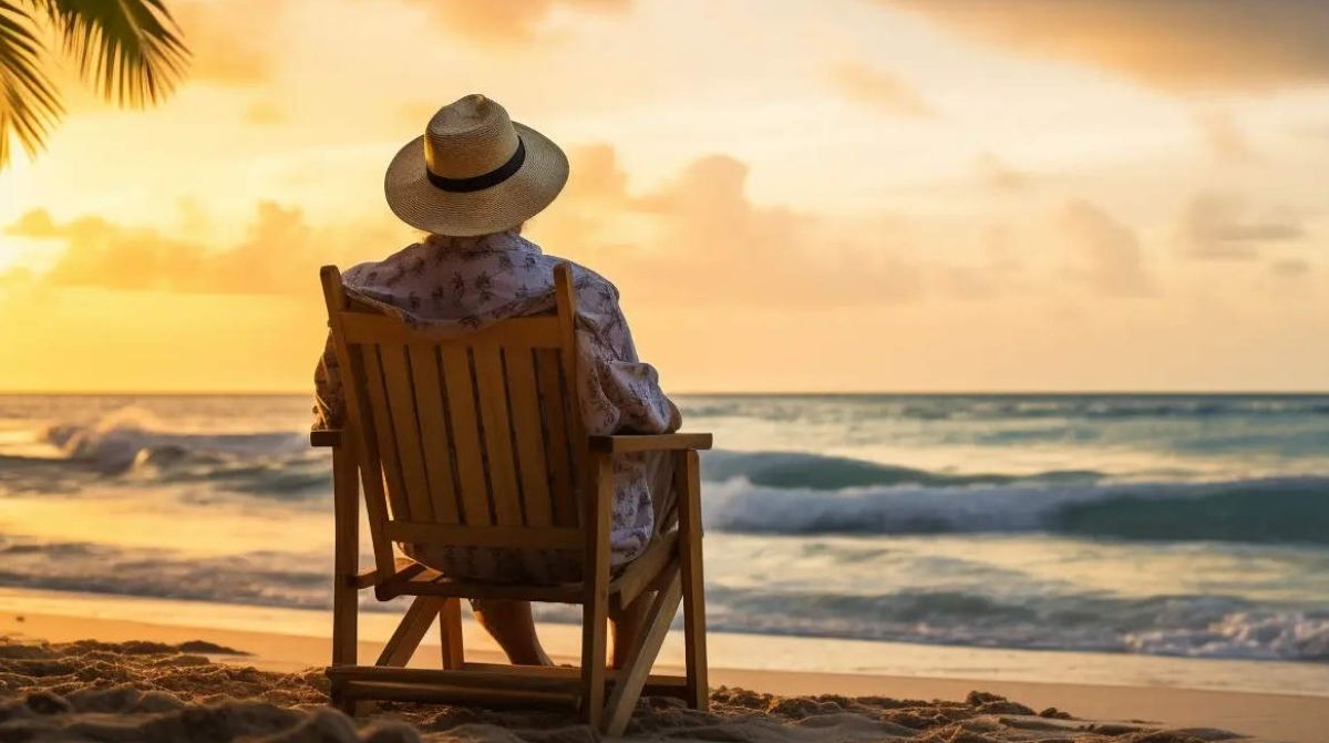 Infoemplea2 42 Persona mayor sentada en la playa al atardecer tras jubilarse anticipadamente