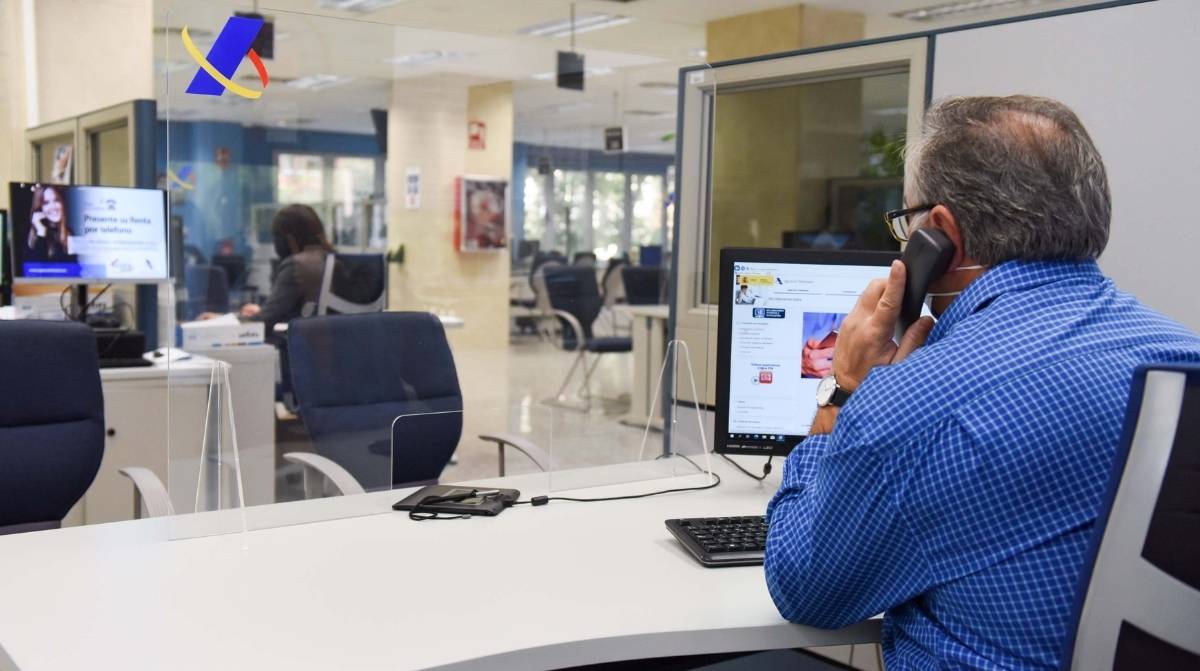 Funcionario atendiendo en oficina pública con nueva jornada laboral de 35 horas en España