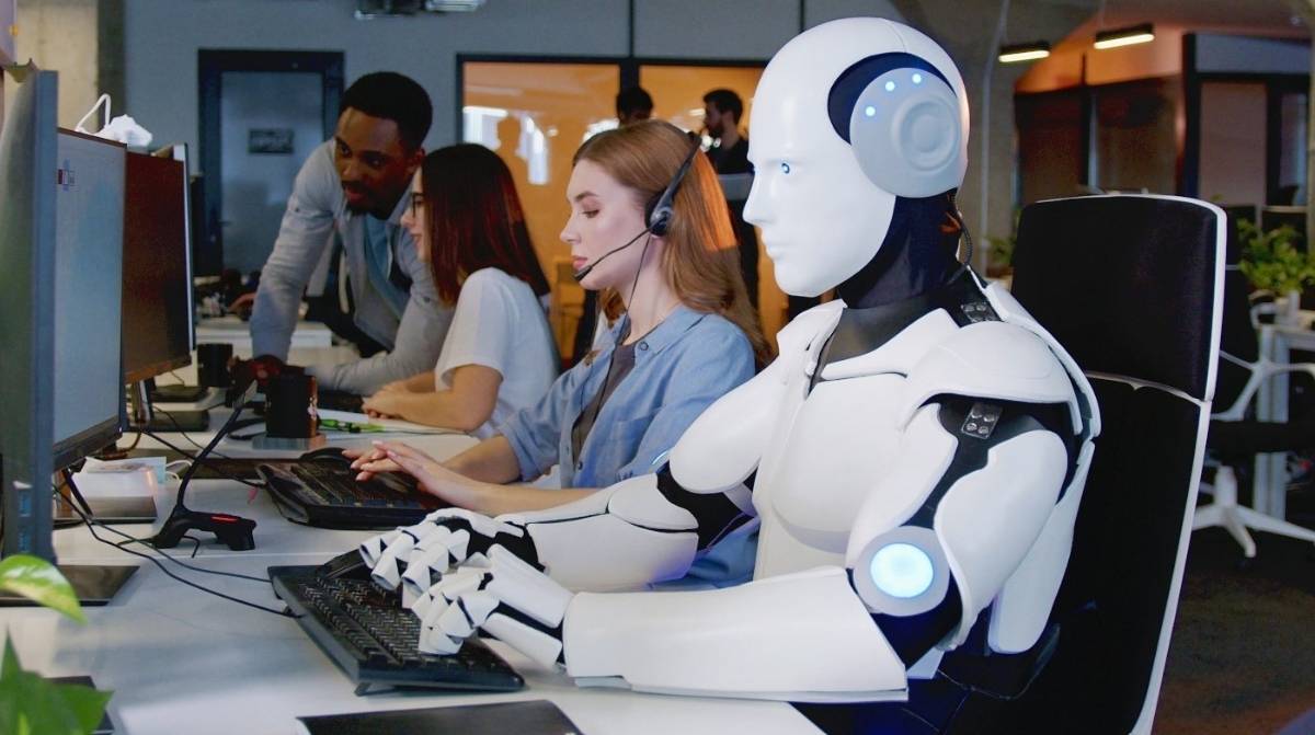 Robot trabajando junto a personas en oficina tecnológica reflejando el impacto de la inteligencia artificial en el empleo