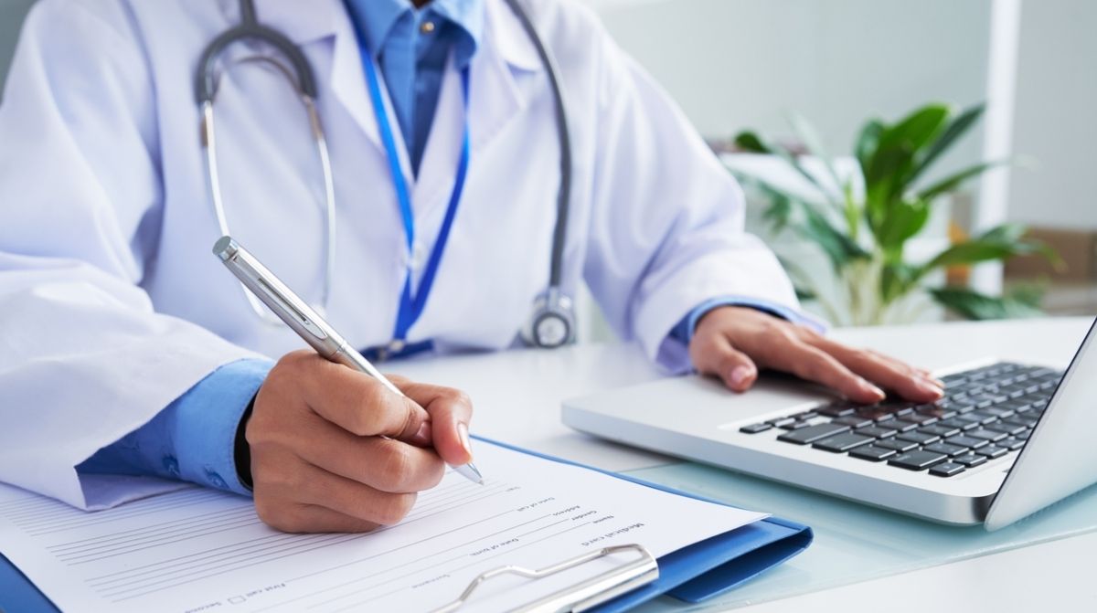 Médico firmando alta médica en consulta relacionada con despido laboral por no reincorporación al trabajo
