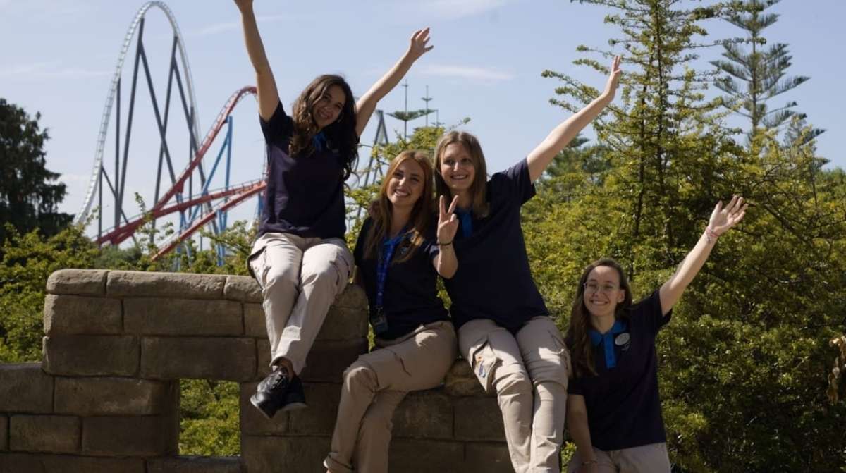 Trabajadores de PortAventura sonriendo en el parque durante jornada laboral sin experiencia previa