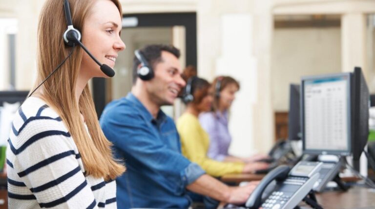 Trabajadores de contact center con auriculares atendiendo llamadas en una oficina de Randstad