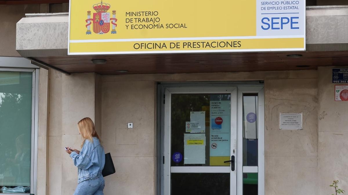 Mujer frente a una oficina del SEPE donde se puede solicitar el subsidio para víctimas de violencia de género o sexual