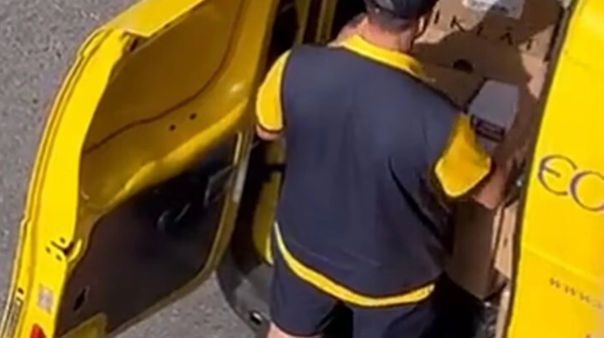 Empleado de Correos cargando paquetes en una furgoneta tras conocerse el despido por quedarse con dinero del cambio de una clienta