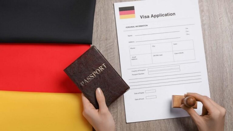 Trabajador revisando documentación para trabajar en Alemania con pasaporte y formulario de solicitud sobre bandera alemana