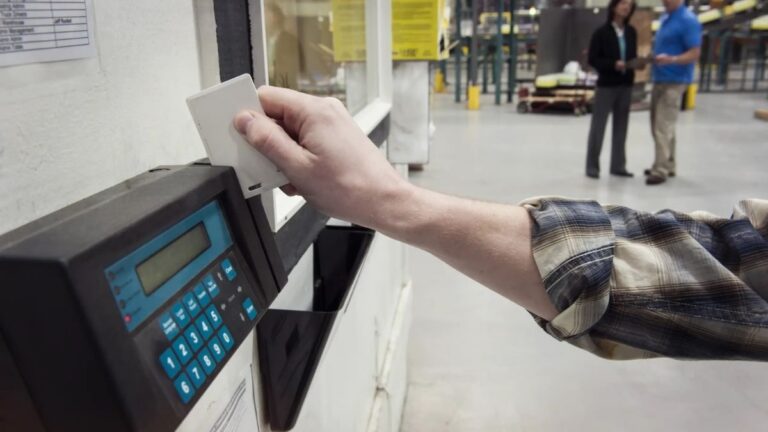 Trabajador fichando en el registro horario de una empresa tras un caso de despido improcedente