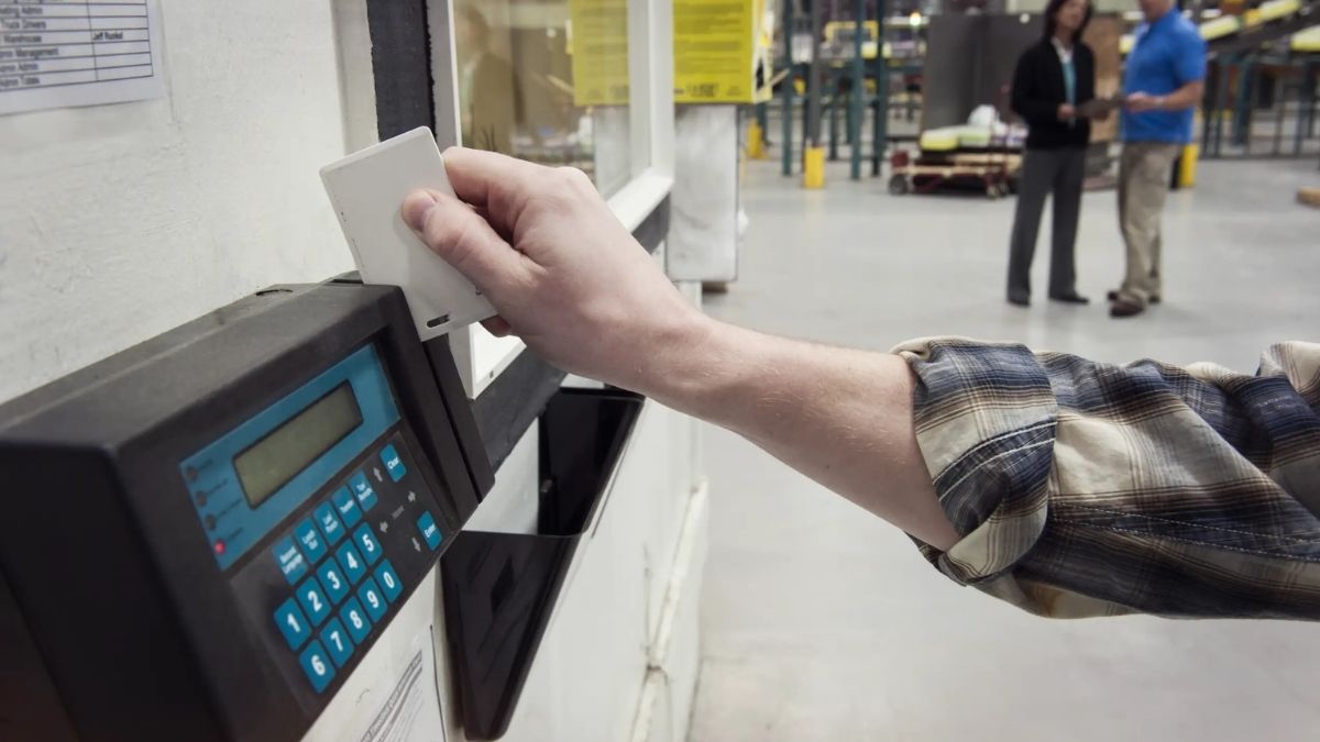 Trabajador fichando en el registro horario de una empresa tras un caso de despido improcedente