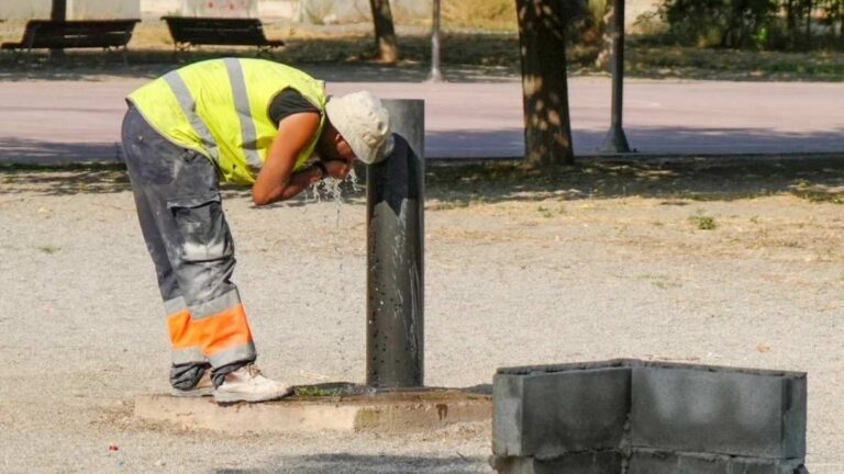 Trabajador al aire libre refrescándose durante un episodio de calor extremo en plena jornada laboral