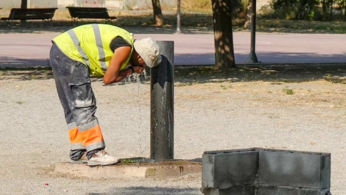 Trabajador al aire libre refrescándose durante un episodio de calor extremo en plena jornada laboral