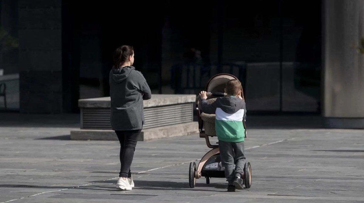 Madre paseando con un bebé en carrito tras la aclaración de la Seguridad Social sobre el permiso por nacimiento hasta los 8 años