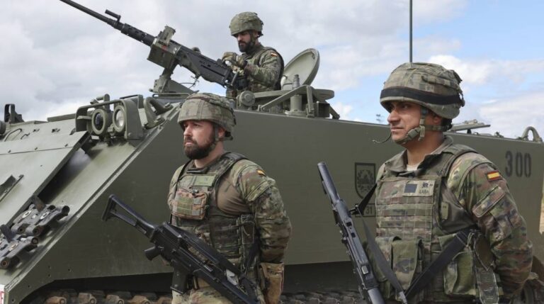 Militares del Ejército de Tierra junto a un vehículo blindado durante unas maniobras militares en España