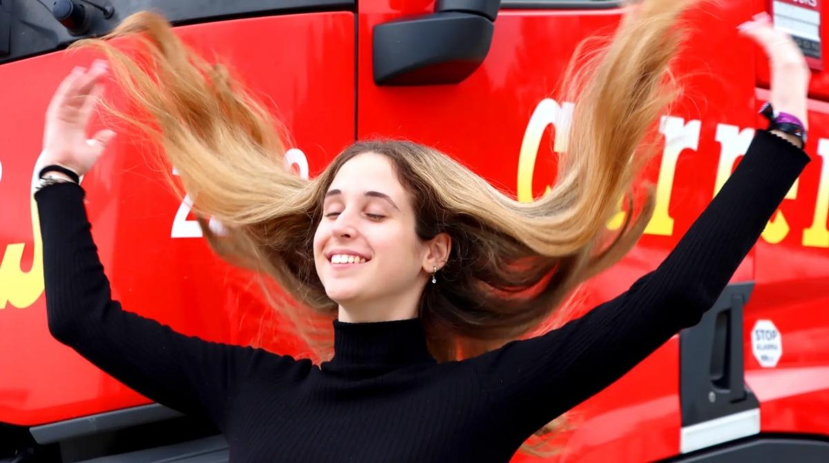 Andrea, camionera de 22 años, posa delante de un camión tras romper estereotipos en el sector del transporte