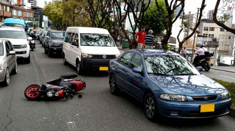 Accidente laboral de tráfico durante el desplazamiento al trabajo con una moto caída y retenciones en carretera