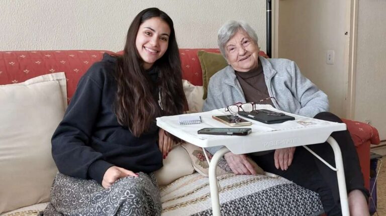 Mujer cuidando de una persona mayor de 65 años en casa para acceder a la deducción de hasta 2.550 euros en la Renta