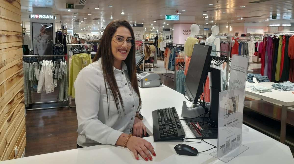 Trabajadora de El Corte Inglés atendiendo en una tienda durante la campaña de contratación de verano 2026