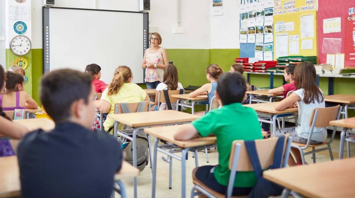 Profesora dando clase a alumnos de infantil y primaria en aula escolar, empleo de maestros en Irlanda