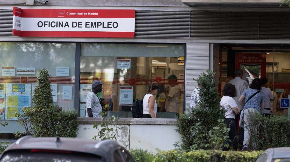 Personas entrando en una oficina de empleo mientras sube la prestación media por desempleo del SEPE