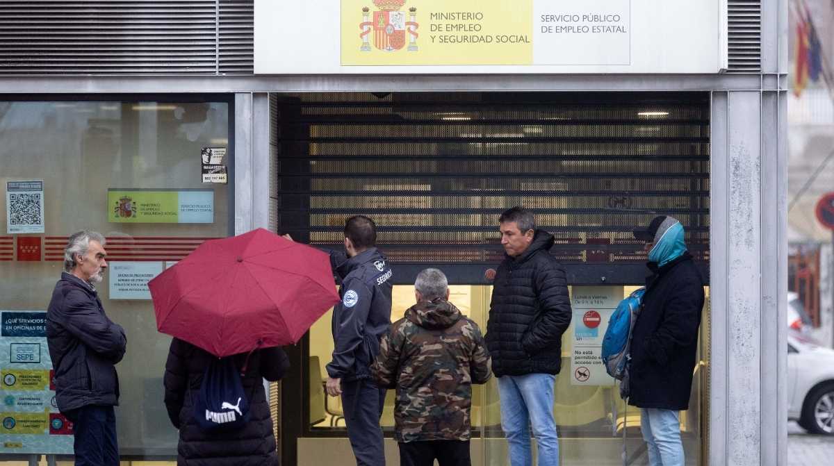 Funcionarios y ciudadanos en la entrada de una oficina del SEPE durante una jornada de atención al público