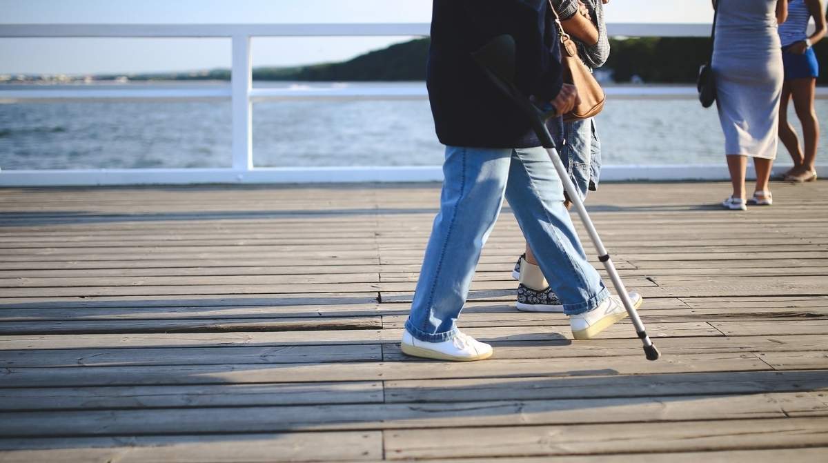 Persona caminando con muletas durante una baja laboral por incapacidad temporal
