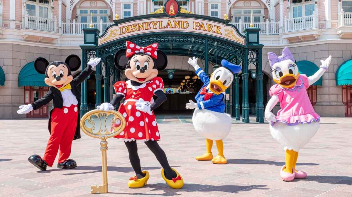 Personajes de Disney frente a la entrada de Disneyland París, donde el SEPE difunde ofertas de empleo para trabajar en el parque.