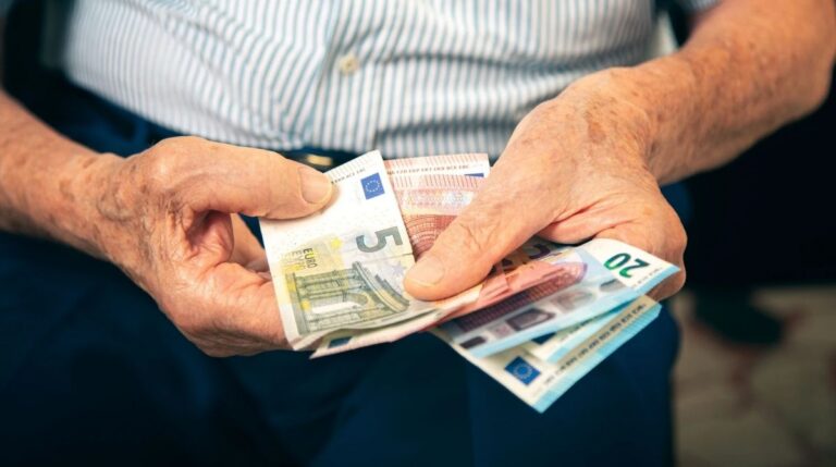 Persona jubilada contando billetes de euro tras reclamar un complemento de la Seguridad Social que aumenta la pensión.