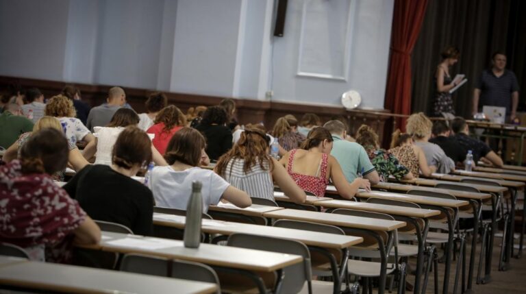 Aspirantes realizando un examen de oposiciones en un aula durante una convocatoria pública.