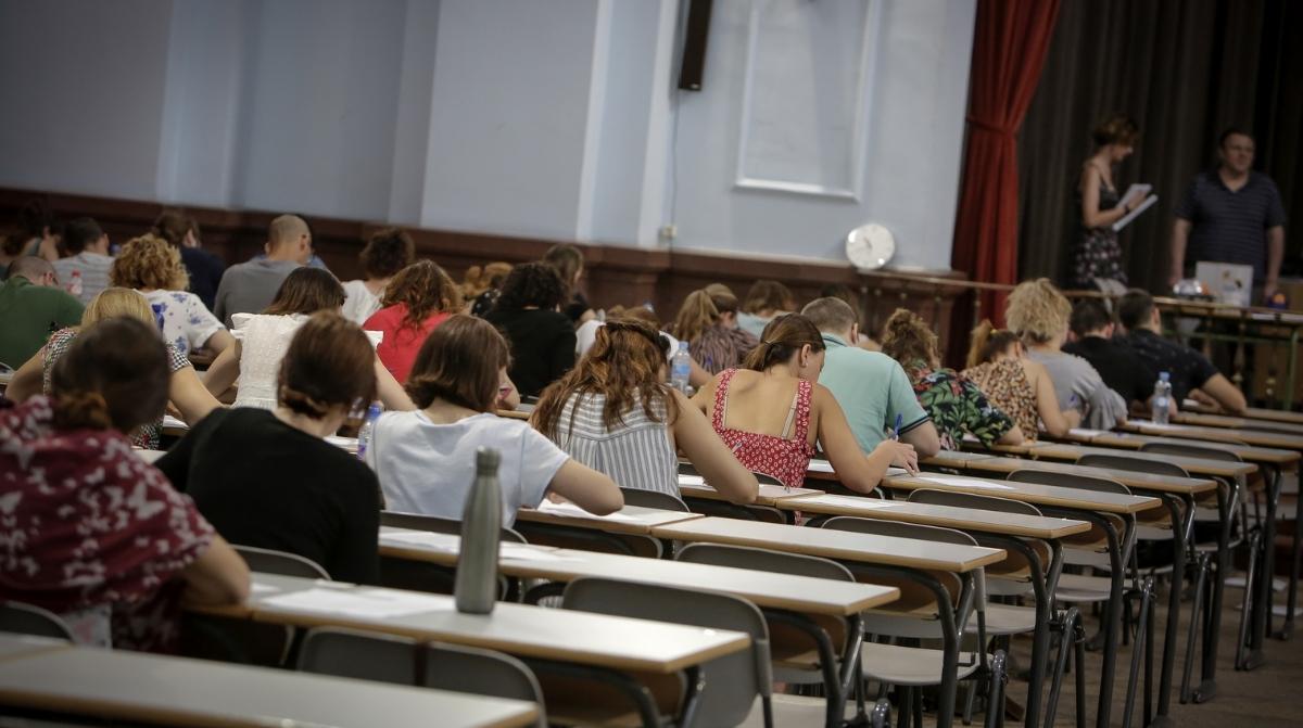 Aspirantes realizando un examen de oposiciones en un aula durante una convocatoria pública.