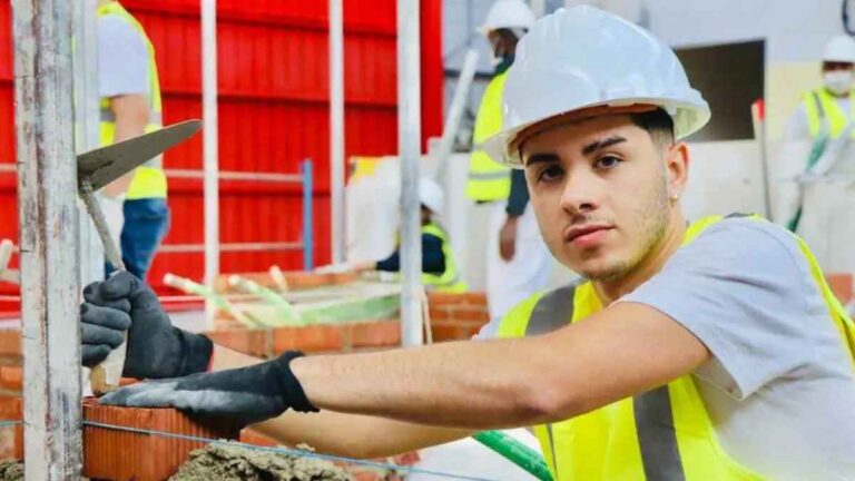 Joven aprendiz de obra trabajando como albañil en una construcción