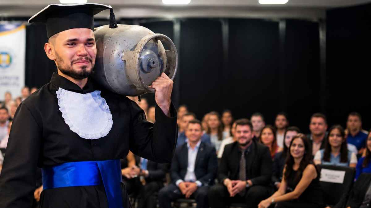 Joven recibe su título universitario con una bombona de gas al hombro durante su graduación para homenajear a su padre.