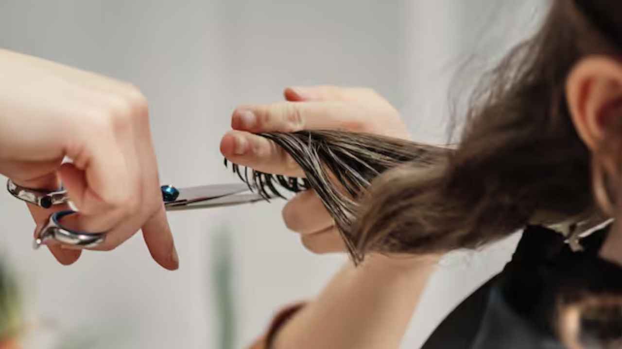 Peluquera cortando el cabello de una clienta en un salón de belleza recibe indemnización