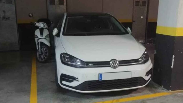 Coche y moto aparcados juntos en una misma plaza de garaje comunitario