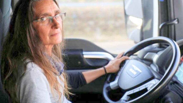 Conductora profesional dentro de la cabina de un camión antes de iniciar una ruta
