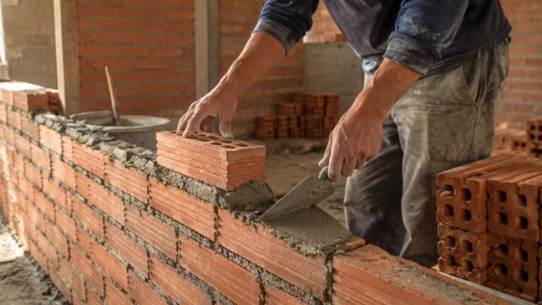 Trabajador colocando ladrillos durante una jornada laboral