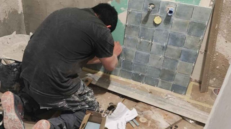 Trabajador reformando un baño en una vivienda