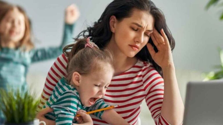 Padre trabajando desde casa con un portátil mientras cuida de su hijo