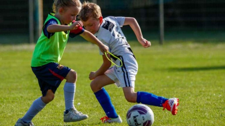 Dos escolares juegan al fútbol en una actividad deportiva en la Comunidad de Madrid