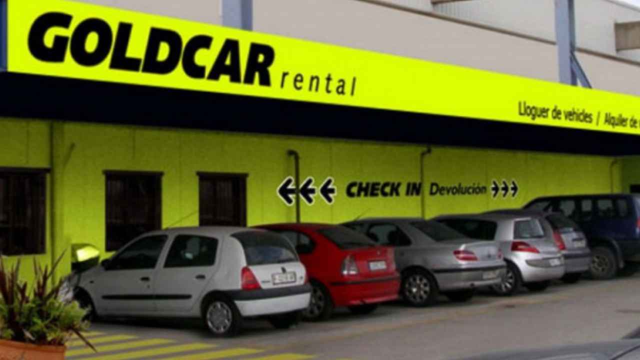 Oficina de Goldcar con varios coches de alquiler aparcados en el exterior