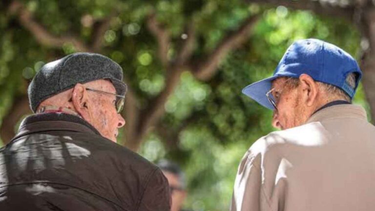 Dos pensionistas sentados en un banco en un parque