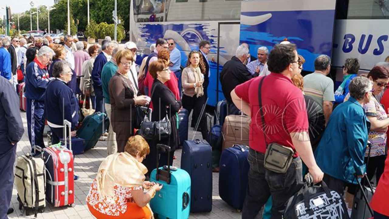 Pensionistas con maletas junto a un autobús para viajar con el Imserso