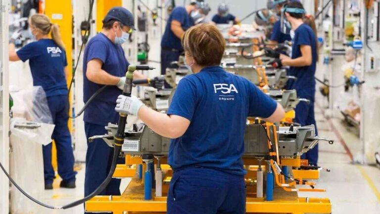 Operarios trabajando en una línea de producción de Stellantis en una fábrica de automóviles.