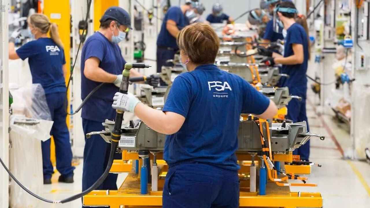 Operarios trabajando en una línea de producción de Stellantis en una fábrica de automóviles.